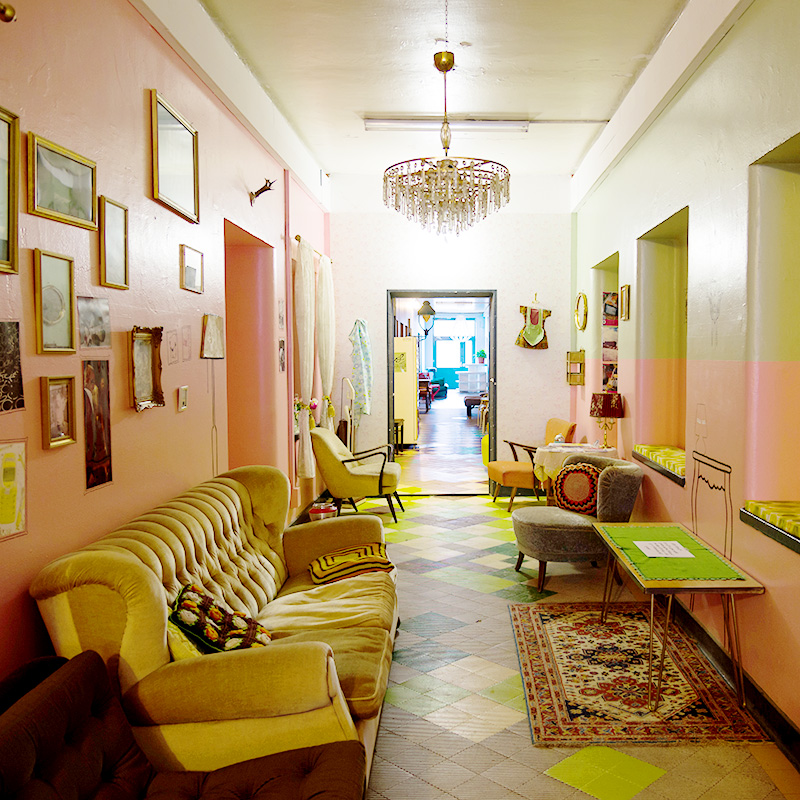 Flur mit Möbeln, rosa Wand und bemaltem Boden